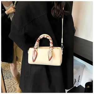 Minimalistische beige leren tas met zijden sjaal om handvat en logo-opdruk