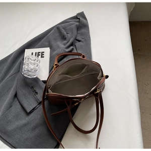 Top view of brown leather handbag interior showing spacious compartment and zipper pocket