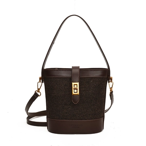 Brown leather and tweed bucket bag with gold clasp and adjustable strap in front view