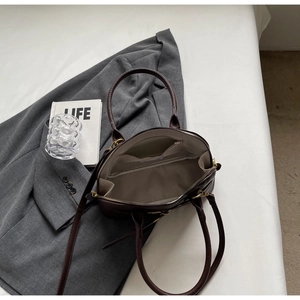 Top-down view of a dark brown leather handbag showing spacious interior and golden hardware