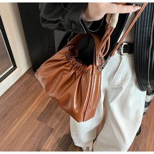 Fashionable brown pleated cloud handbag with shiny leather texture and crossbody strap
