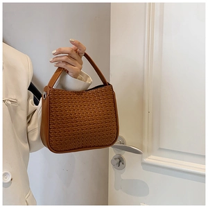 Close-up of caramel woven texture on retro tote bag with silver metal buckle detail