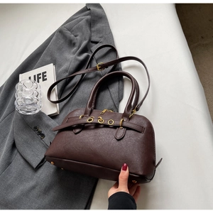 Detailed view of dark brown leather Boston bag with litchi texture and gold hardware