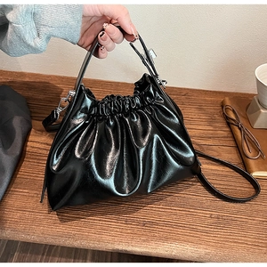 Detail showing the pleated texture and silver hardware of the black cloud handbag