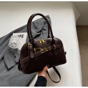 Detail of dark brown leather Boston bag with gold ring buckle and shoulder strap