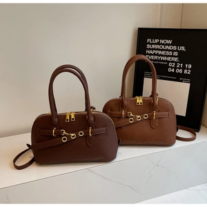 Detail of dark brown and caramel Boston bags featuring gold hardware and zippers