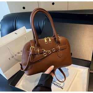 Top view of caramel brown leather shell bag with gold hardware in gift box