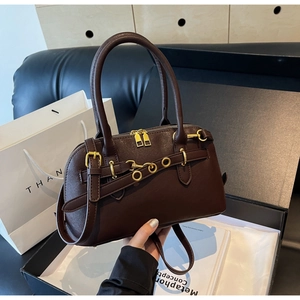 Close-up of brown leather Boston bag with gold hardware and smooth double zipper details