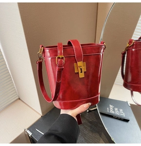 Vue détaillée du sac seau en cuir ciré rouge vintage avec fermoir rotatif en bronze