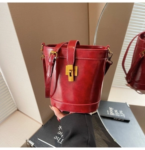 Gros plan du sac seau bordeaux vintage avec texture cuir ciré et boucle en métal doré élégant