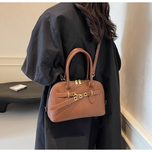 Detailed back view of a brown leather Boston bag with gold zippers and metal eyelets