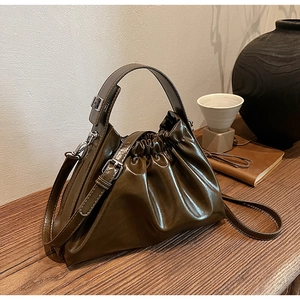 Detail view of olive green cloud bag with pleated texture and stylish shoulder strap
