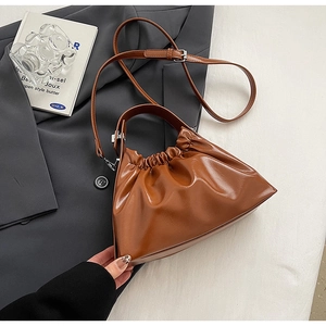 Detailed view of the brown ruched dumpling bag with smooth leather and silver metal hooks