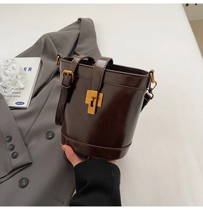Vue détaillée du sac seau en cuir marron foncé avec boucle dorée rétro et bandoulière réglable