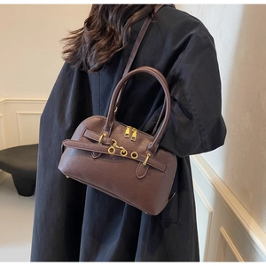 Brown leather Boston bag detail with gold ring accents and adjustable shoulder strap style
