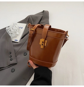 Détail du sac seau vintage en cuir ciré marron foncé avec boucle métallique dorée chic