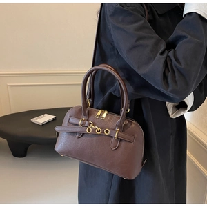 Deep brown matte leather boston bag detail with elegant gold buckles and zippers