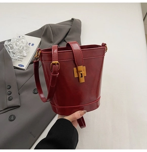 Vue détaillée du sac seau bordeaux en cuir ciré avec fermoir rotatif doré de haute qualité