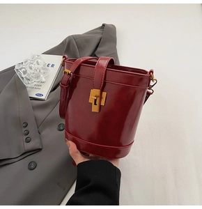 Détail du sac seau bordeaux en cuir ciré avec fermoir métallique doré de style rétro