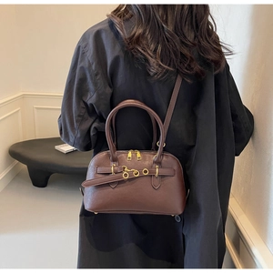Detail of dark brown leather Boston bag with gold ring buckle and sleek twin zippers