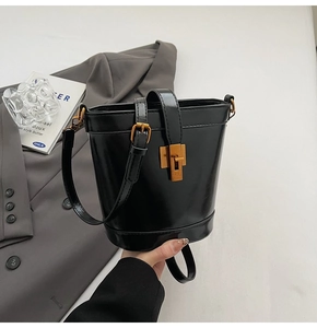 Détail du sac seau en cuir ciré rétro avec boucle carrée dorée et coutures de précision