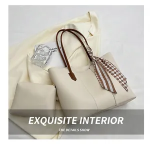 Detail of beige tote bag with inner pouch, dark brown handles and checkered silk scarf