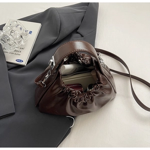 Detail showing the spacious interior of this brown ruched cloud bag with daily essentials