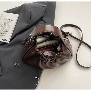 Top view of dark brown pleated cloud bag showing interior storage for phone and lipstick