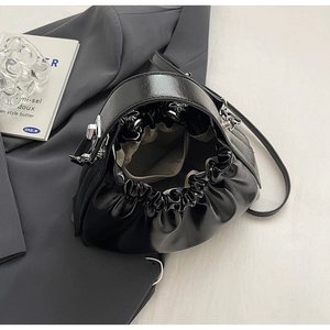 Detail view of black pleated bucket bag with silver drawstring and spacious interior