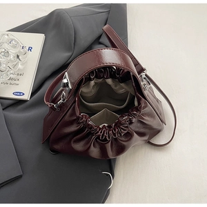 Detail view of burgundy cloud bag with pleated drawstring closure and inner pocket