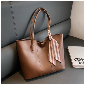 Detailed view of dark brown tote bag with decorative striped scarf and matte texture