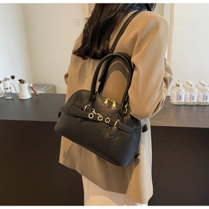 Detail of black matte leather shoulder bag with gold rings and dual zipper system
