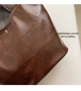 Detailopname van de retro bruine leren shopper met grote patchwork stiksels en textuur