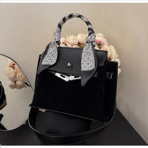 Detail of black matte leather Kelly bag with silk scarf handle and silver metal hardware