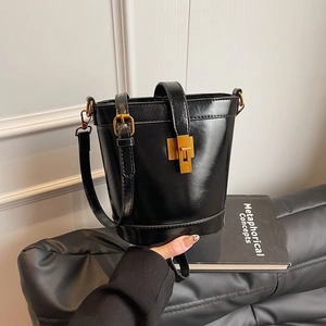 Sac seau chic en cuir ciré noir avec ferrures dorées vintage et bandoulière
