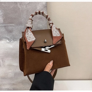 Detail of vintage matte brown Kelly bag with silk scarf handle and leather stitching
