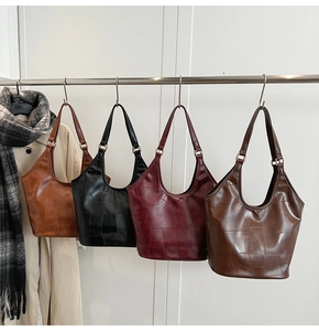 Detail van vier retro hobo-tassen van kunstleer in karamel, zwart, wijnrood en koffie