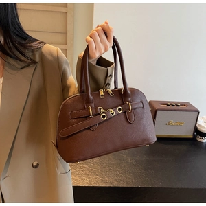 Detailed view of deep brown vintage dome bag with premium leather texture and gold hardware