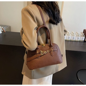 Brown faux leather crossbody bag with gold hardware worn with a khaki blazer