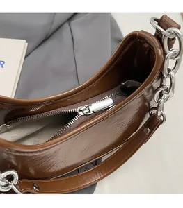 Détail de la fermeture éclair argentée et doublure grise du sac porté épaule marron
