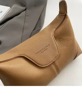 Close-up of brown litchi pattern leather texture and embossed Fashion & Bags logo