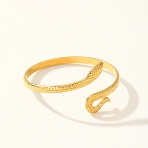 Detailed close-up of golden snake-shaped bracelet with intricate scale texture carvings