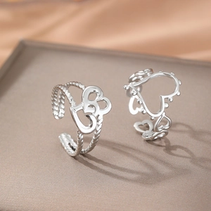 Vintage hollow heart stainless steel open rings in silver finish on a display stand
