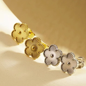 Elegant gold and silver four-leaf clover stud earrings with fine textured petals