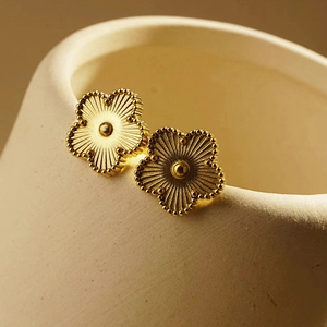 Elegant gold five-petal flower stud earrings with radial texture and beaded edges