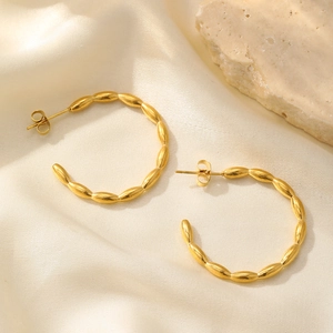 Détail de boucles d'oreilles en C plaquées or 18k avec texture de perles de grain de riz