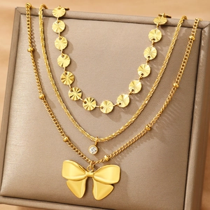 Collier doré à trois rangs avec disques gaufrés, pendentif cristal et grand nœud poli