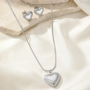 Elegant heart pendant necklace and earrings set with radial texture on silk fabric