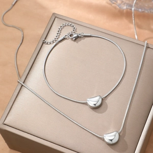 Polished silver bean pendant necklace and bracelet set with sleek snake chain for women