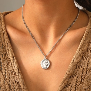Vue macro d'un pendentif pièce romaine antique sur une chaîne en acier inoxydable argent